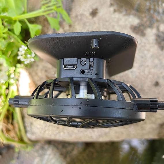 Close up of a black solar powered fan in solar fan hat. side view. natural blurred background