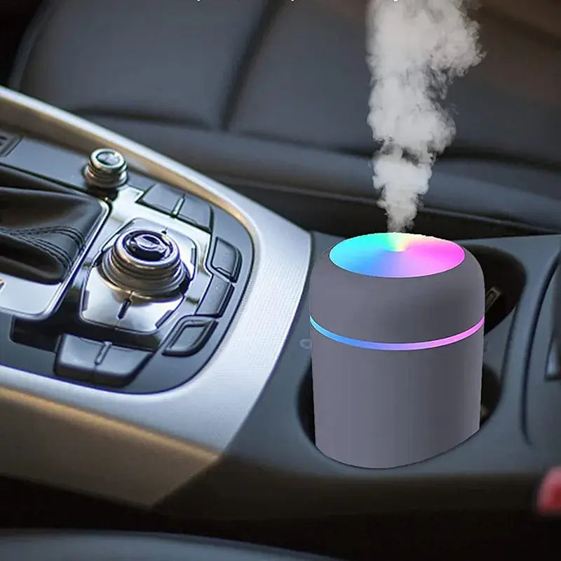 Mini Portable Air Humidifier in vehicle holder releasing mist.
