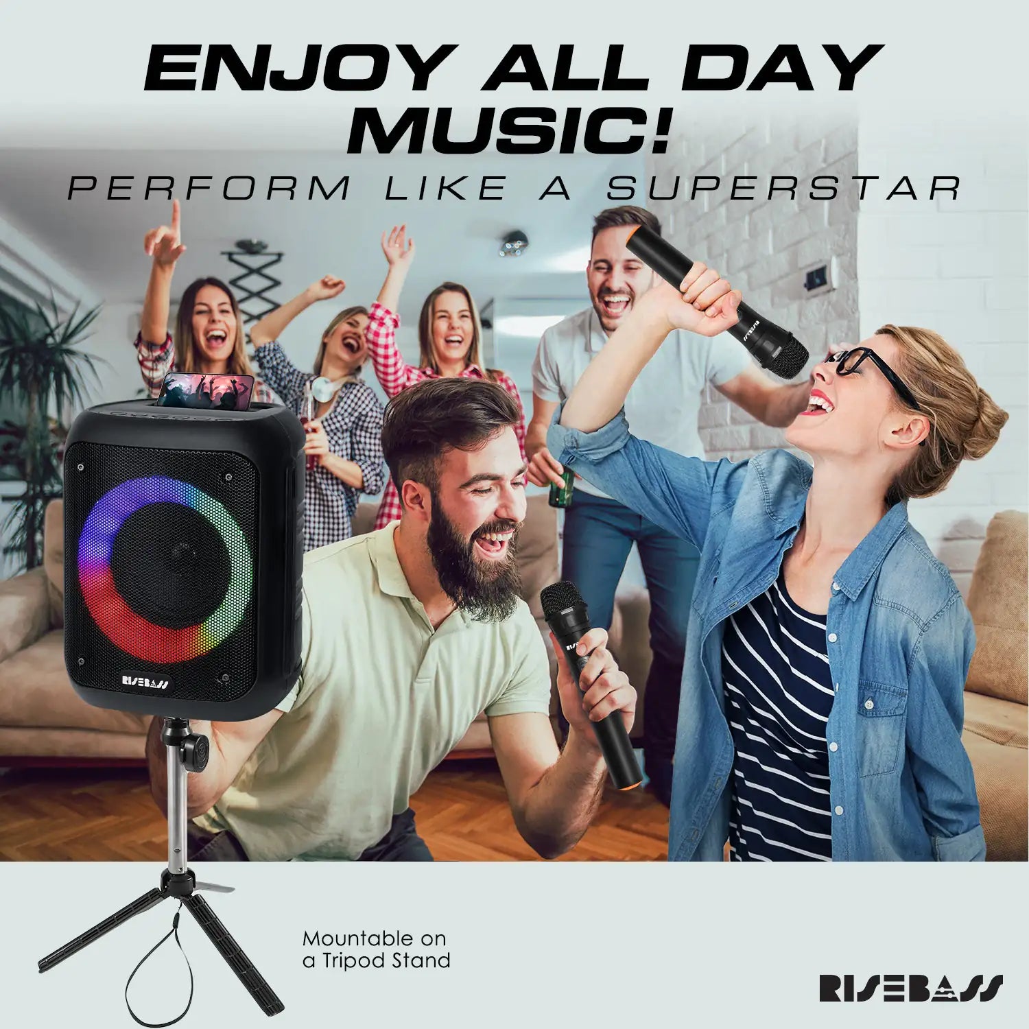 karaoke machine with LED lights and 2 wireless microphones. phone on top of karaoke machine.  Man & woman singing in front of people in living room.